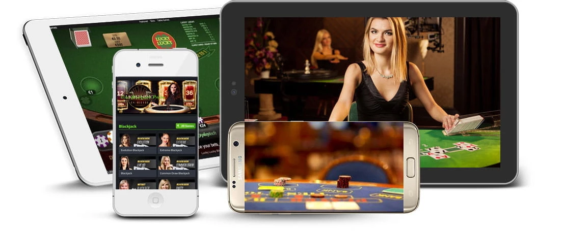 Es sind zwei Tablets zu sehen, eines weiß und eines schwarz, mit verschiedenen Casinospielen auf dem Bildschirm. Überlagert von den beiden Tablets ist ein weißes iPhone zu sehen, auf dem die Auswahl an Roulette-Spielen zu sehen ist, und ein goldenes Samsung, auf dem ein Kartenspiel gespielt wird.