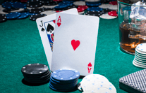 Auf einem Tisch liegen zwei Karten und mehrere Stapel Casino-Chips.