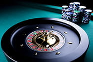 Ein Casino-Roulette und mehrere Stapel Chips.