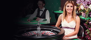 Ein Croupier sitzt an einem Rouletterad.